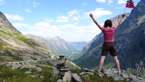 Touristen-mit-norwegischer-Flagge-im-Kommandobereich/Trollstigen