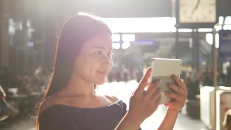 Junge-Asiatin-mit-Tablet-in-den-Straßen-der-Stadt