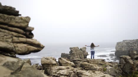 Unrecognizable-female-on-rocky-seashore