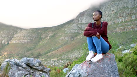 Woman-sitting-on-a-rock-at-countryside-4k