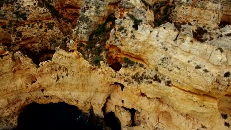 Acantilados-con-mar,-cerca-de-puente-faro-Piedade-Lagos-Portugal-Vista-aérea