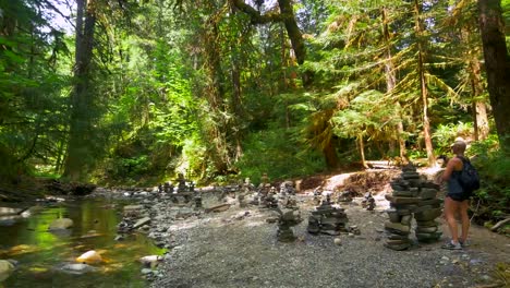 Forest-Stream-in-Nature,-Young-Woman-Explores-Rock-Sculpture-Formations