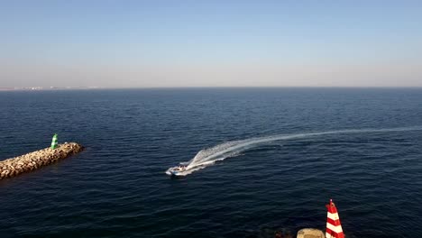 Motor-boat-enters-the-harbor-of-Lagos,-Portugal-aerial-view