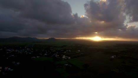 Aerial-view-of-Mauritius-Island,-forests,-farm,-fields-and-hills-against-sunset-sky-and-pink-clouds