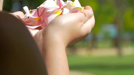 Mujer-soplando-pétalos-de-flores-de-las-manos