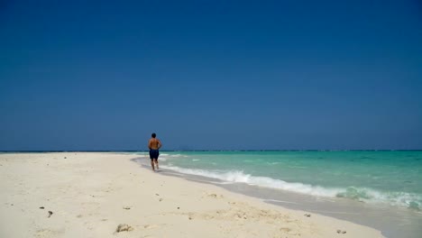 Mann-läuft-am-Strand