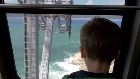 Boy-looking-at-sea-from-moving-funicular-in-Rosh-Hanikra