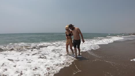 Young-couple-walking-together-on-a-beach.