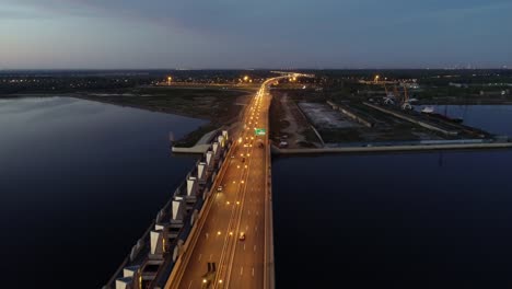 Cars-moving-on-highway-bridge-on-the-sea-directing-to-the-industrial