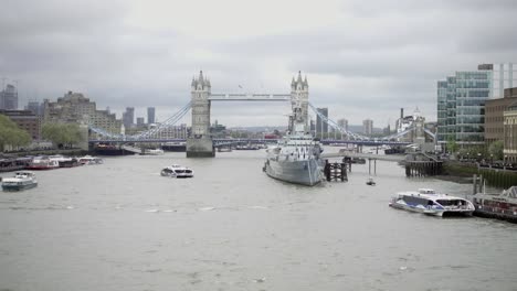 far-shot-of-boats-and-Tower-Bridge-on-the-Thames-River-on-cloudy-day-in-London