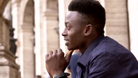 Smiling-attractive-young-black-man-contemplating-the-city