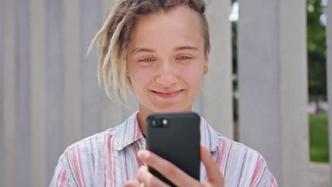 Young-Lady-with-Modern-Hairstyle-Using-Phone-in-Town