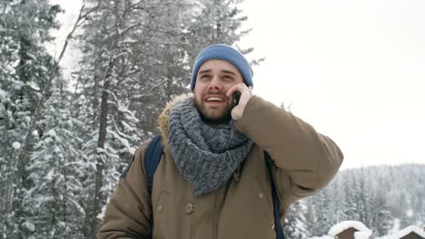 Man-Talking-on-Phone-Outdoors-at-Snowy-Day