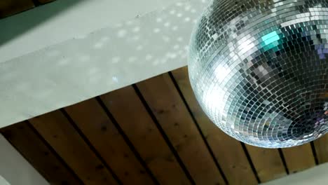 spinning-disco-ball-under-a-wooden-ceiling