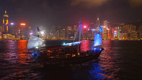 Nahaufnahme-einer-Dschunke-Segeln-auf-Victoria-Harbour-in-Hongkong-bei-Nacht