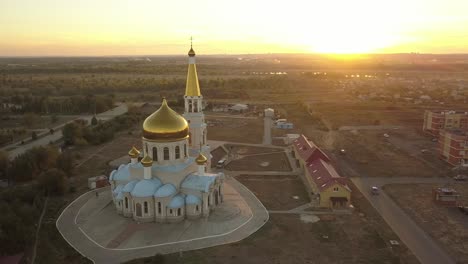 aerial-gorgeous-gold-and-white-church-during-the-sunset-against-the-amazing-skyline