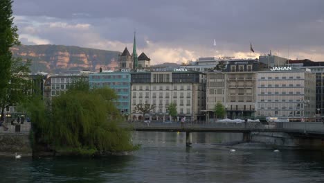 puente-sobre-el-río-al-atardecer-cielo-Ginebra-ciudad-Bahía-lenta-panorama-4k-Suiza