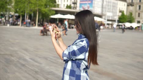 Young-Asian-woman-using-mobile-phone-in-city-streets