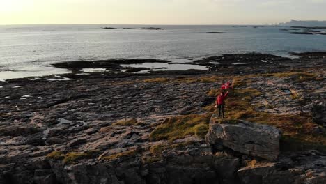 Andøya-Insel-Meeresküste-und-Touristen-mit-norwegischer-Flagge