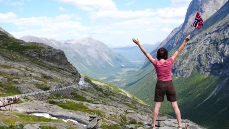 Touristen-mit-norwegischer-Flagge-im-Kommandobereich/Trollstigen