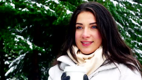 Woman-in-warm-clothing-having-coffee-during-snowfall