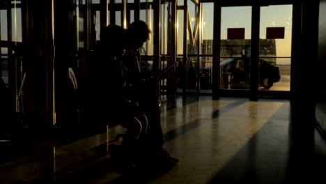 At-airport-of-Thessaloniki,-Greece-in-the-waiting-room-sits-a-mother-with-her-son-and-watching-videos-on-tablet