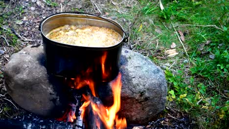 Cooking-soup-on-a-fire-pot.-Summer-camping-in-forest