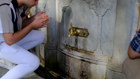 Hagia-Sophia-Istanbul-Young-man-washing-his-hands-fountain-Hagia-Sophia