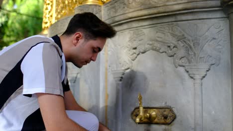 Young-man-washing-his-hands-fountain-Hagia-Sophia