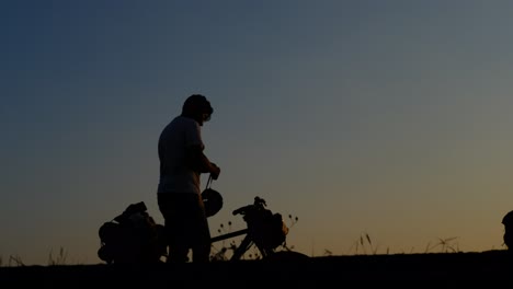 Man-wearing-bicycle-helmet-sunset