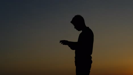 Silhouette-of-teenager-smoking-while-using-phone