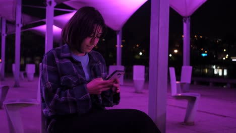 Young-girl-sitting-outside-and-messaging
