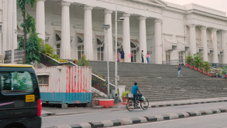Ciclista-Fuera-Del-Edificio-De-La-Biblioteca-Asiática-En-Mumbai,-India