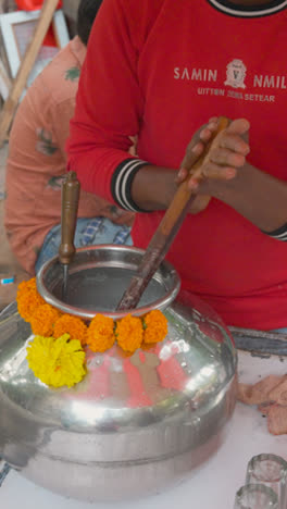 Video-Vertical-Cerca-De-Un-Hombre-En-Un-Puesto-Batiendo-Cuajada-Para-Hacer-Suero-De-Leche-O-Chaas-En-Mumbai,-India