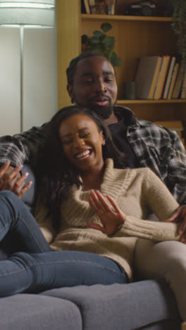 Vertical-Video-Of-Loving-Couple-Relaxing-At-Home-Sitting-On-Sofa-Talking-Together