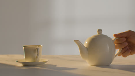 Studioaufnahme-Einer-Person,-Die-Mit-Teekanne-1-Eine-Traditionelle-Britische-Tasse-Tee-Zubereitet