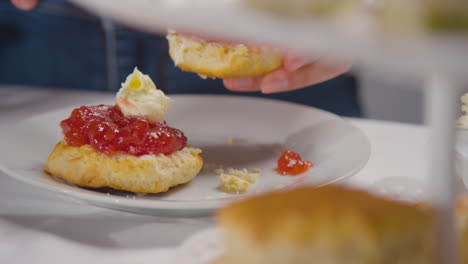 Close-Up-Shot-Of-Person-With-Traditional-British-Afternoon-Tea-With-Scones-Cream-And-Jam-3