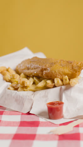 Vertikale-Videostudioaufnahme-Einer-Traditionellen-Britischen-Mahlzeit-Zum-Mitnehmen-Mit-Fish-And-Chips