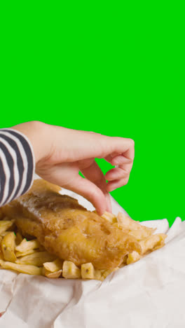 Video-Vertical-De-Personas-Usando-Los-Dedos-Para-Comer-Comida-Tradicional-Británica-Para-Llevar-De-Pescado-Y-Papas-Fritas-En-El-Fondo-De-Pantalla-Verde-1