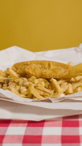 Vertical-Video-Studio-Shot-Of-Traditional-British-Takeaway-Meal-Of-Fish-And-Chips-1