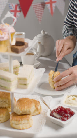 Foto-De-Estudio-De-Vídeo-Vertical-De-Una-Persona-Comiendo-El-Tradicional-Té-Británico-De-La-Tarde-Con-Bollos-De-Crema-Y-Mermelada.