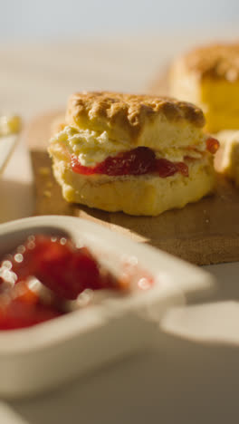 Vertikales-Video-Eines-Traditionellen-Britischen-Nachmittagstees-Mit-Scones,-Sahne-Und-Marmelade