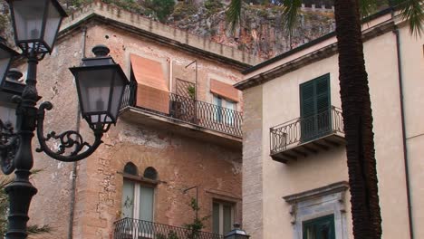 Street-lamps-and-brick-buildings-are-within-close-proximity-of-one-another-in-Cefalu-Italy--