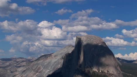 Un-Lapso-De-Tiempo-De-Nubes-Blancas-Sobre-Un-Cielo-Azul-Y-Una-Cordillera-Rocosa-En-El-Parque-Nacional-De-Yosemite,-California-1