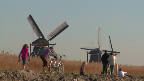 Dutch-citizens-walk-on-a-footpath-in-front-of-windmills-
