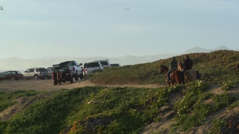 People-ride-horses-along-a-hillside-in-Central-California