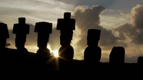 The-sun-peeks-out-from-behind-an-Easter-Island-statue