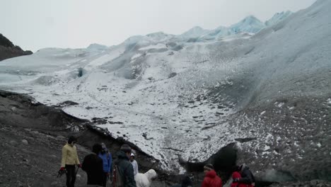 Hikers-gather-at-the-base-of-a-glacier-for-a-trek