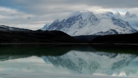Pan-across-a-beautiful-lake-in-front-of-the-peaks-of-Torres-Del-Paine-in-Patagonia-Argentina