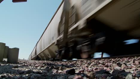 Low-angle-of-a-train-passing-with-roadbed-in-foreground-1